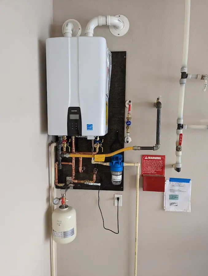 Professional plumber installing copper piping in a Minot AFB home